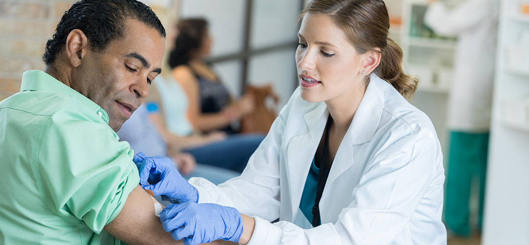 Caring healthcare professional places bandage on man's arm