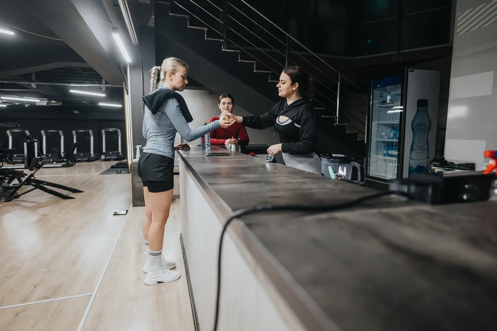 A group of women checking in at a gym reception